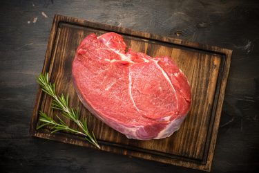 A large piece of beef chop on a cutting board